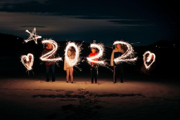Kids on the beach at night making 2022 with sparklers