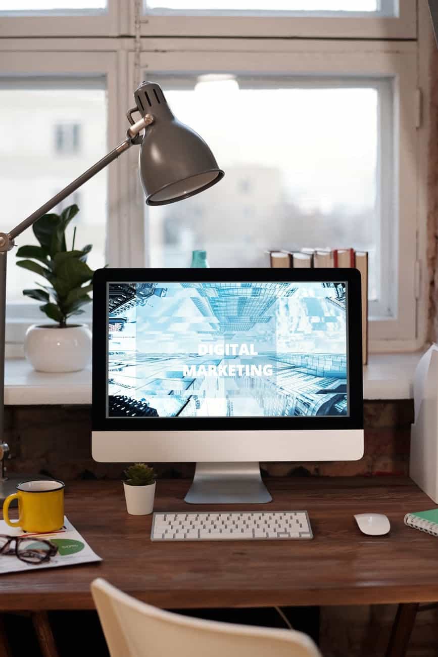 Computer monitor on a desk with text "Digital Marketing" on the screen