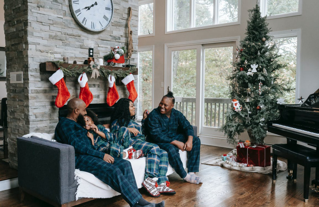 Happy family sitting on the sofa in their pyjamas celebrating Christmas.