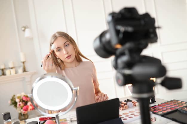 A social media influencer creating content - applying makeup