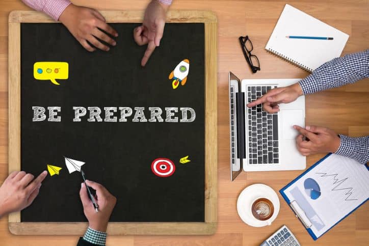 Chalk board with text, "be prepared" and hands pointing to the board