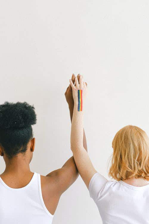 Two American women in an politiclly-correct marketing ad campaign belonging to different races joining hands against racism.