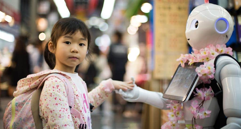 Little girl holding a greeting robots hand | AI influencer marketing