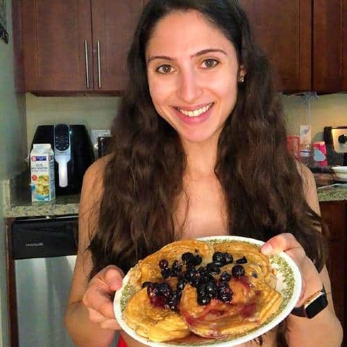 Amanda Esmailian showing a plate of homemade pancakes in the kitchen | IG post