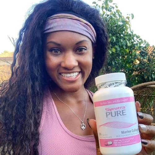 Brittany Noelle promoting a bottle of Synutra Pure | Black Influencers Featured on Afluencer