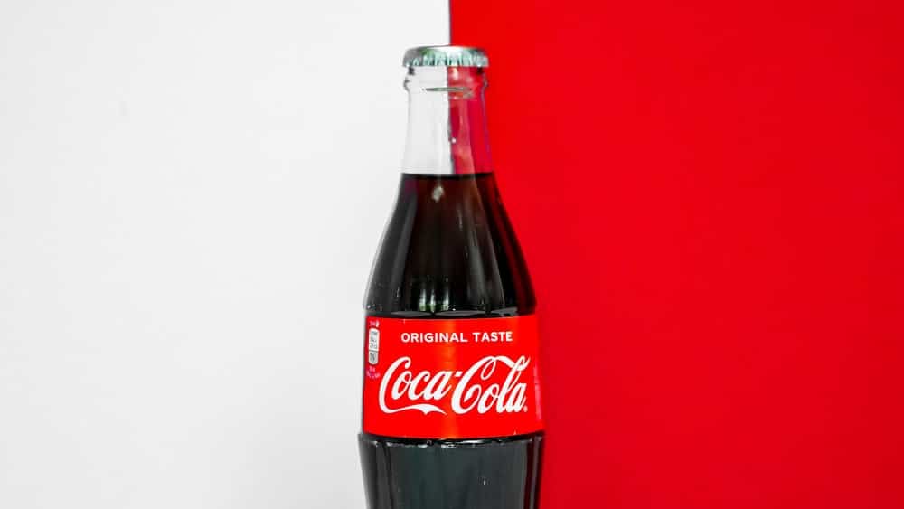 A bottle of coca-cola with split color background, white and red