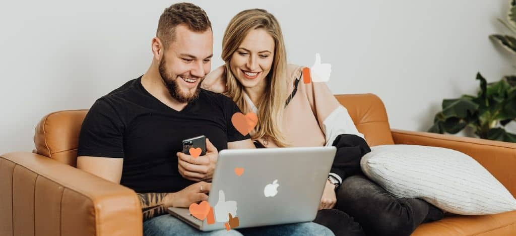 Couple on sofa happily engaging on social media | Apply to Collabs