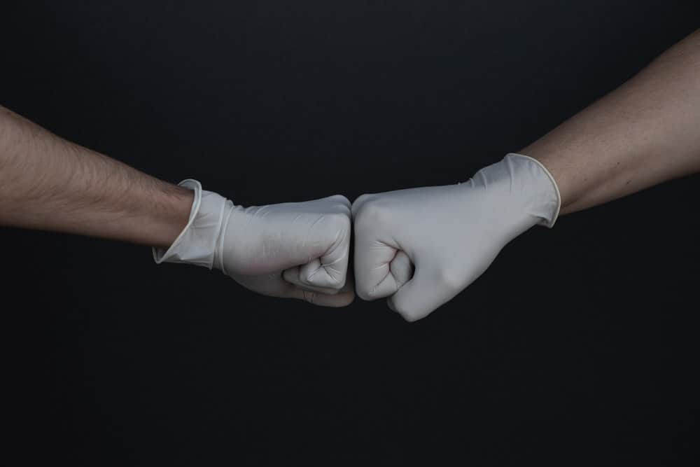 fist bump while wearing latex gloves | Be an Influencer during Covid