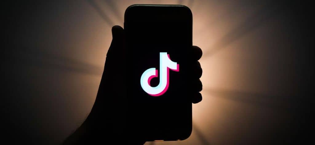 Silhouette of hand and mobile phone | TikTok Influencer Marketing