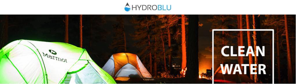 Hydroblu | Camping tents in dark forest with camp fire