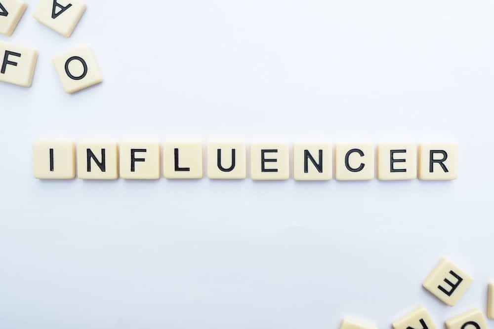 scrabble pieces spell the word INFLUENCER 