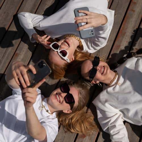 Influencer girls lying head to head taking selfies