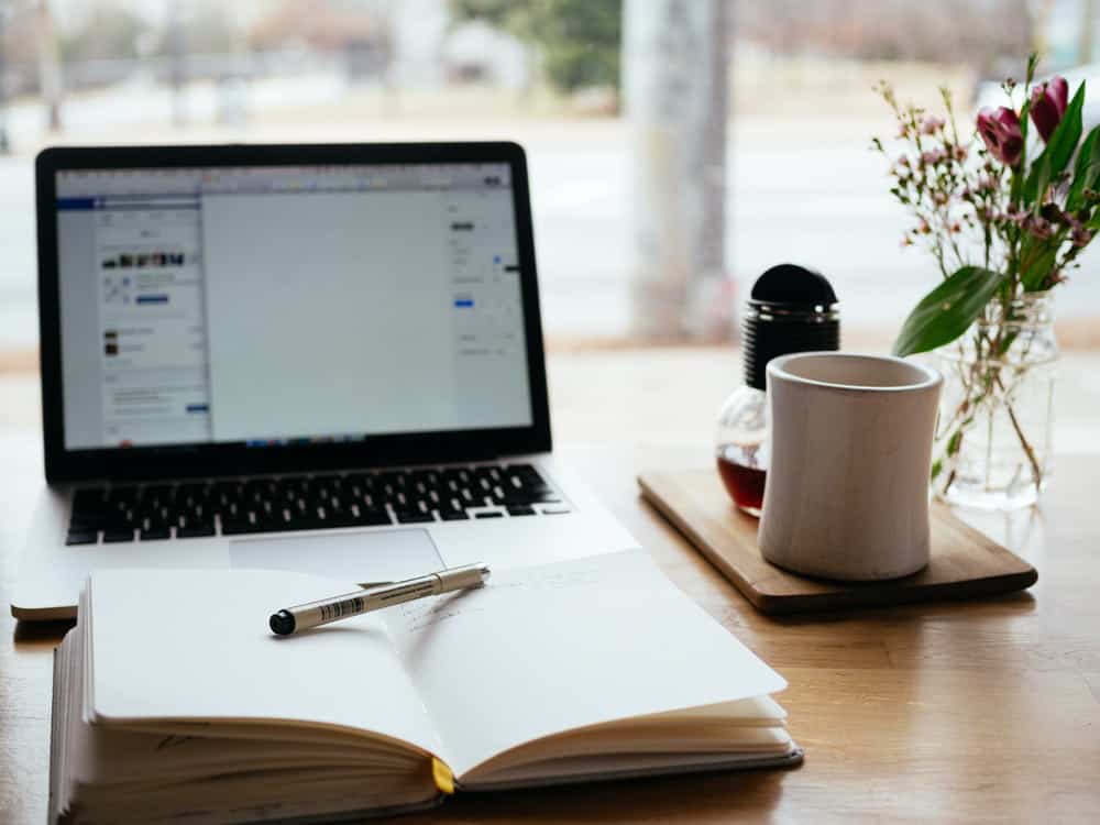 An education influencer’s desk with notepad and laptop open