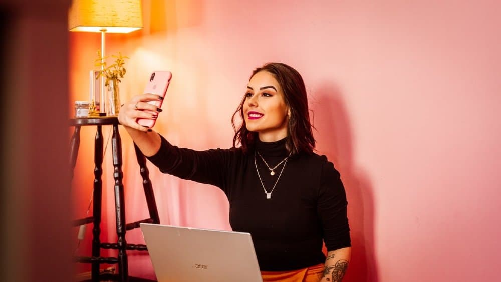 influencer taking a selfie with a pink mobile phone