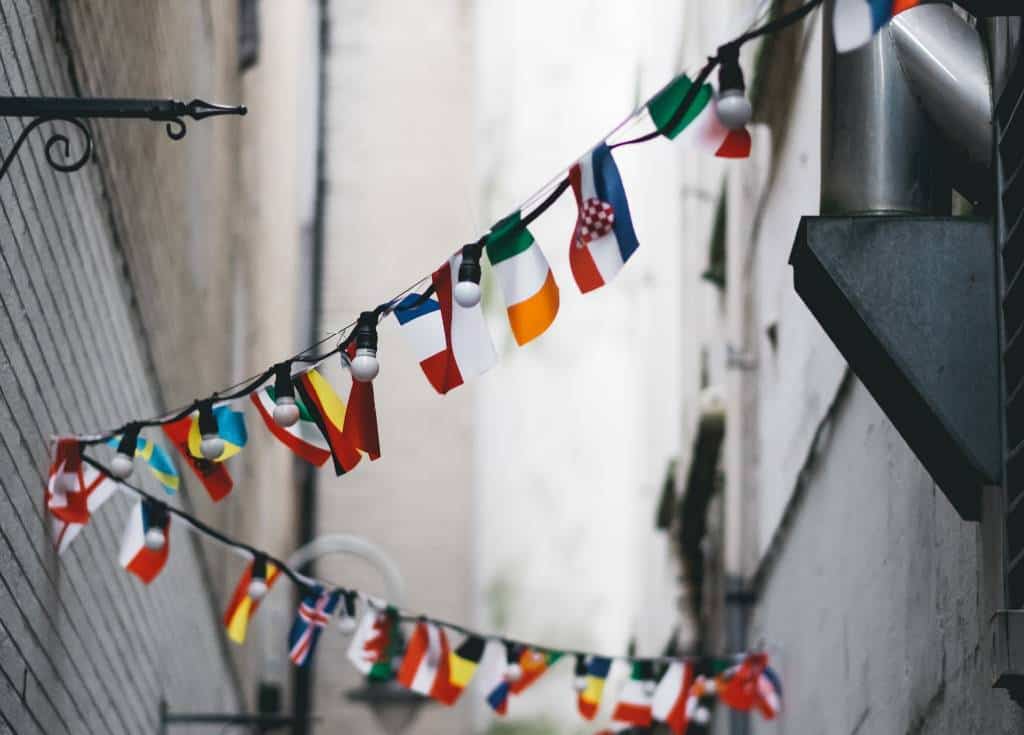 Mini flags hanging from cables in an alleyway | International brands