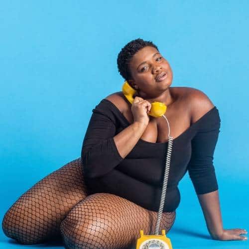 Jessamyn Stanley photoshoot with yellow old-school telephone and blue background
