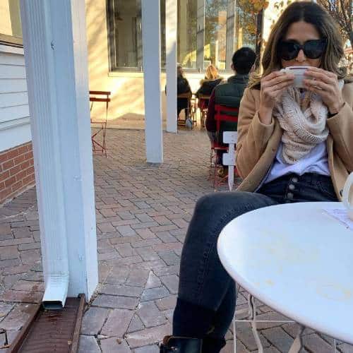 Katie Lemons sitting at an outdoor cafe drinking coffee