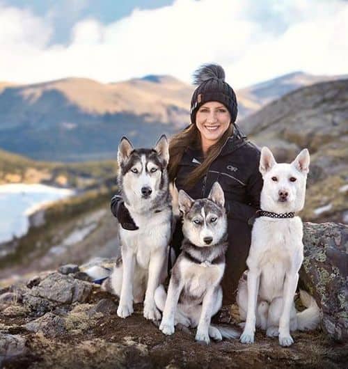 Katlin Longfield and her pet huskies on top of a mountain