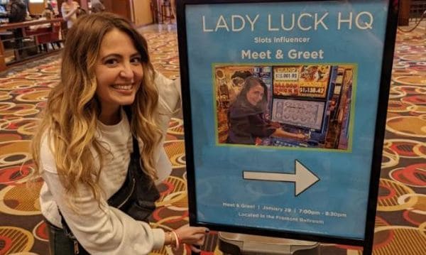 Lady Luck in front of her meet and greet board in a casino