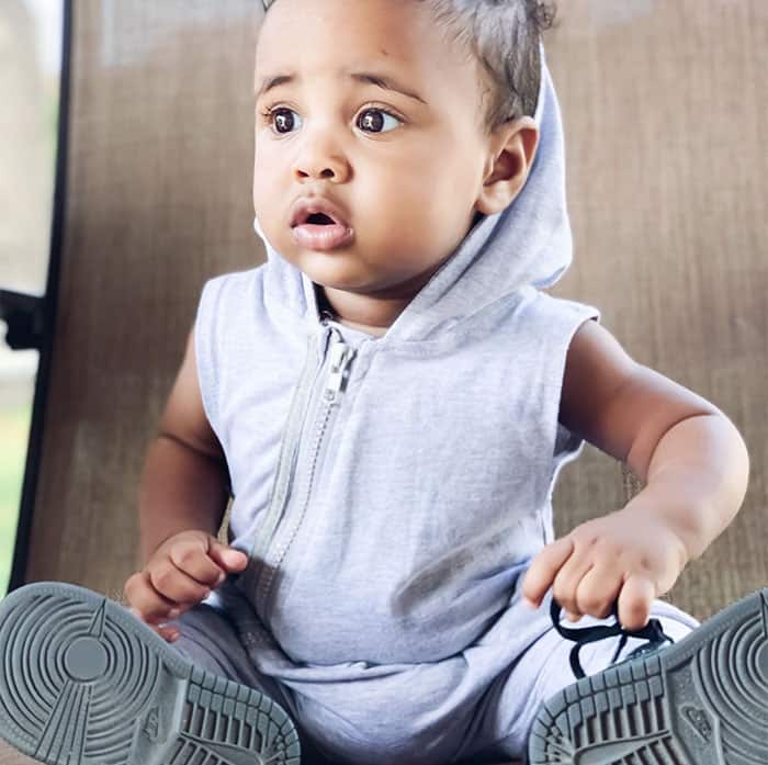 Baby boy in grey sleeveless hoodie and Nike sneakers