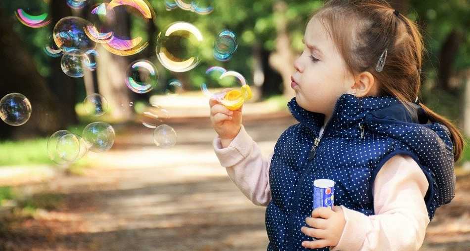 Little girl blowing bubbles outside | Influencers under 10