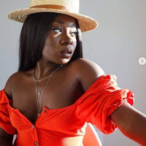 Lynda Jay wearing a straw hat and sexy orange dress