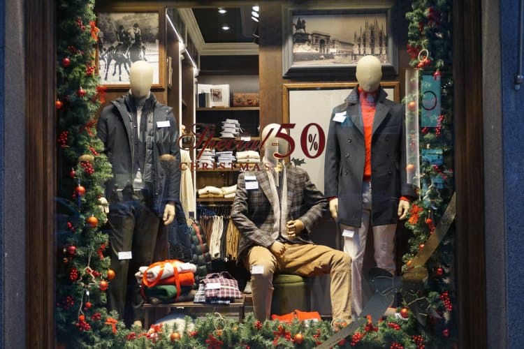 Mannequins in display window of men's wear shop with Christmas discounts