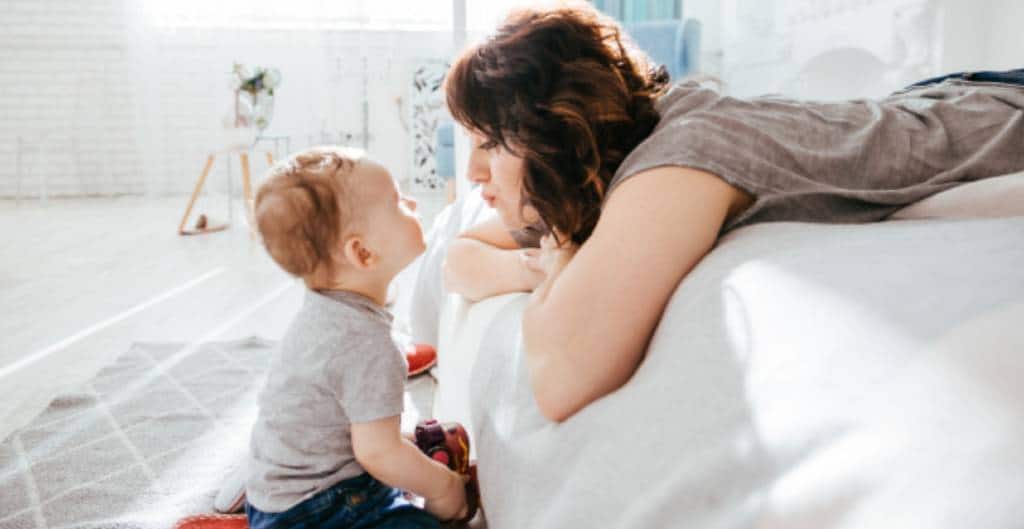 Mother and Baby Playing by the Edge of the Bed