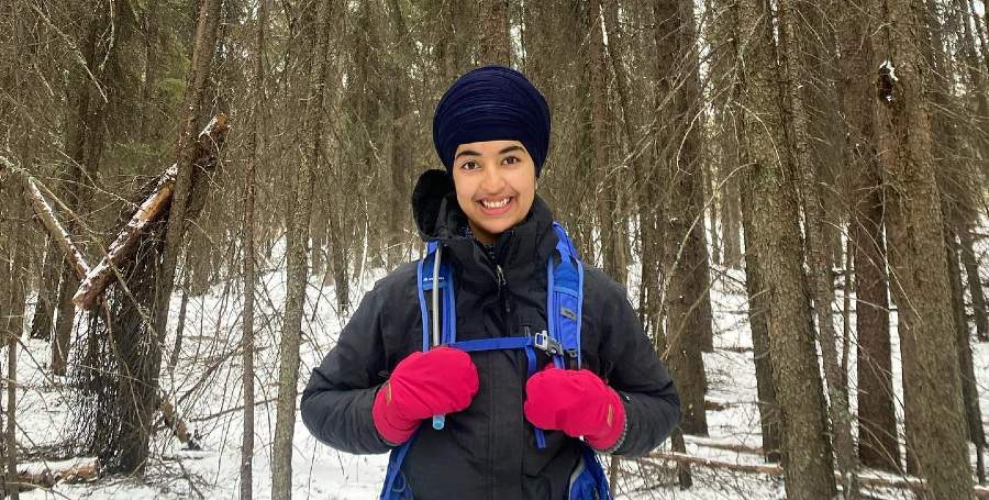 Ramnik Kaur backpacking in a snowy forest