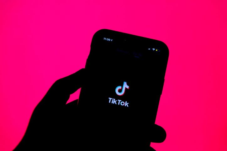 Mobile and hand silhouette with TikTok logo