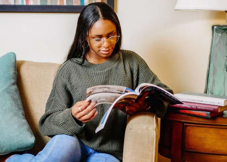 Tangie Seals on the sofa reading a book | Stock Market Investors Featured on Afluencer