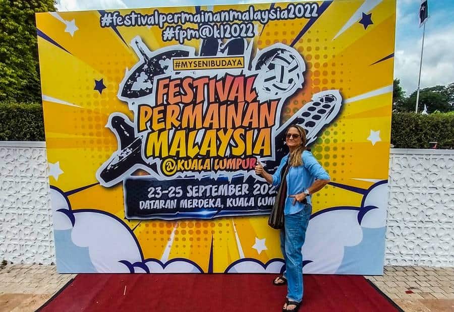 Vanessa Workman posing infront festival permainan malaysia signboard