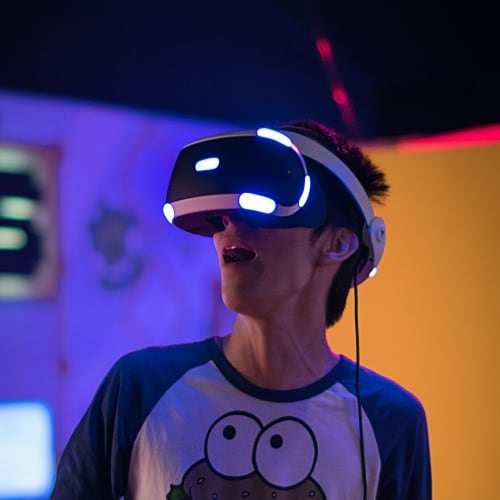 Man amazed testing VR goggle while wearing cookie monster t-shirt