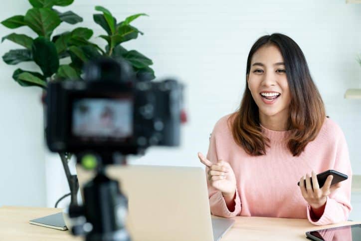 Influener in pink sweater speaking in front of the camera