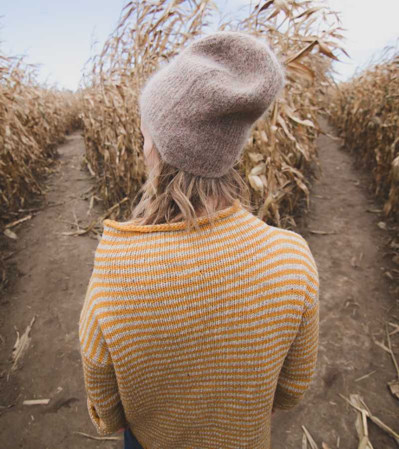 Woman deciding which path to take in the cornfield
