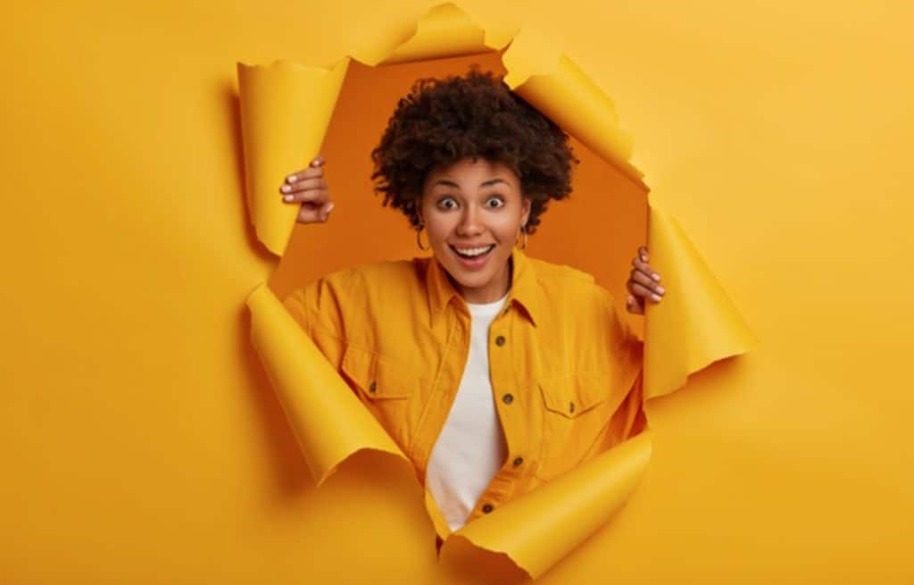Girl in yellow break through yellow paper wall | Step to Start Influencer Marketing