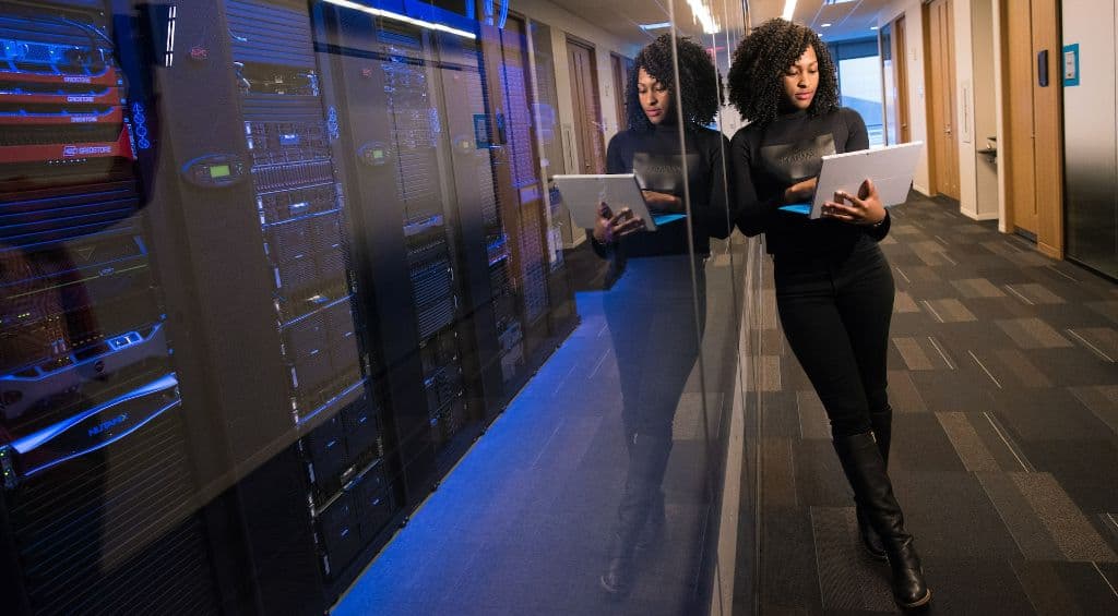 Woman in office searching for influencers on a laptop next to big ai computers